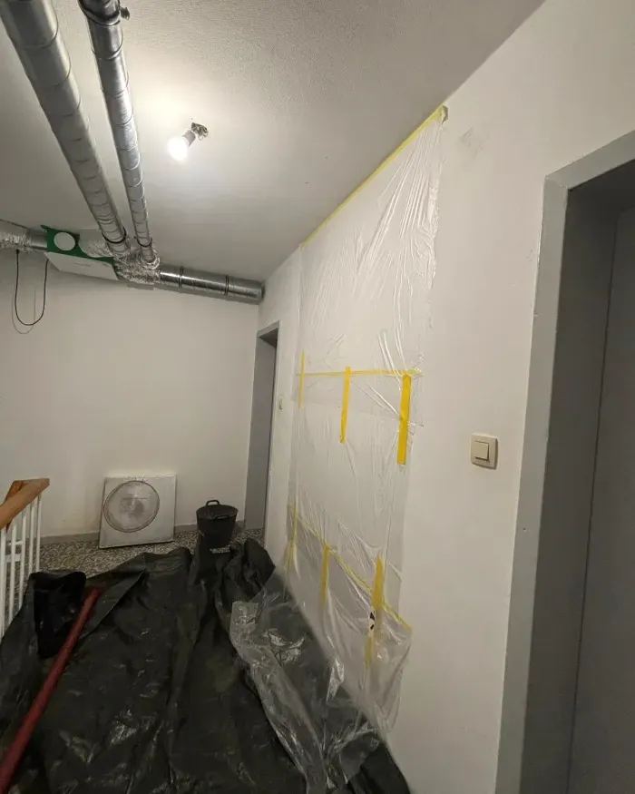 Palier protégé avant l’intervention : film plastique au mur, bâches au sol.