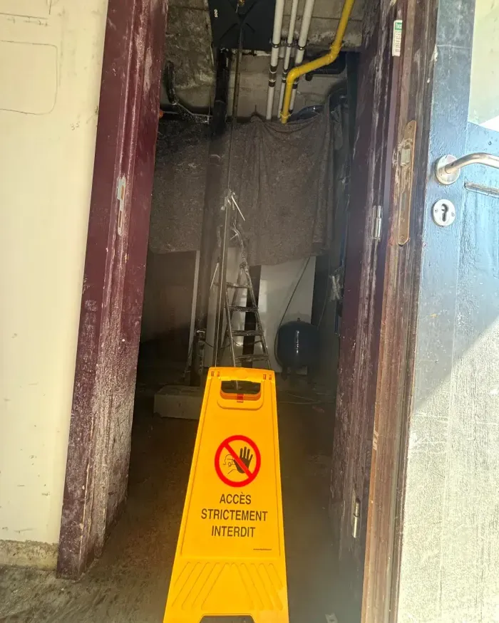Accès au local technique fermé par un panneau « Accès strictement interdit ».