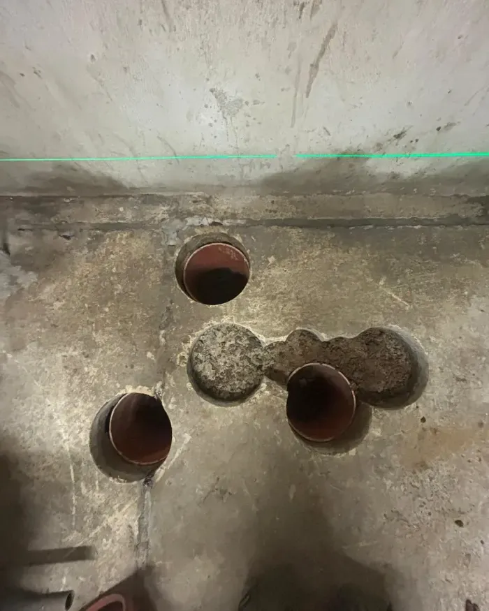 Carottages dans la dalle de la cave, une ligne laser tracée sur le mur.