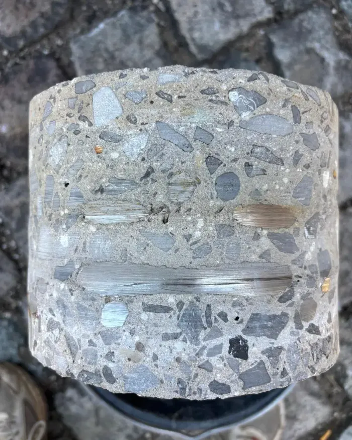 Carotte de béton extraite, armatures d’acier tranchées nettes.