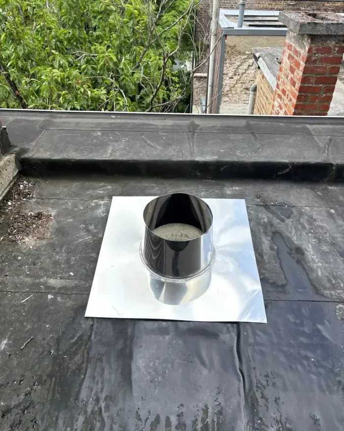 Manchon en inox et sa platine posés sur la sortie en toiture.